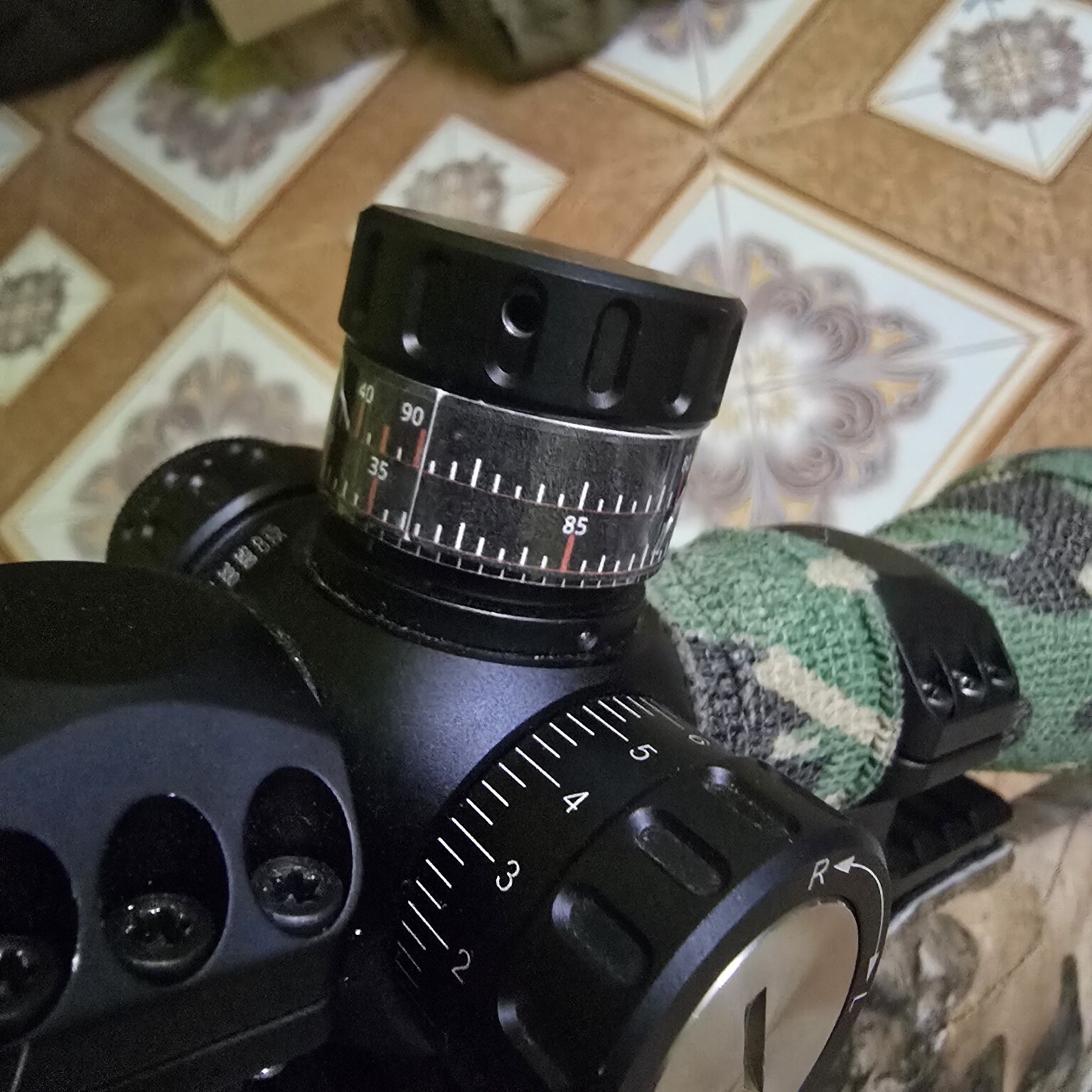 Black multi-row turret label with white ruler marks and red click references